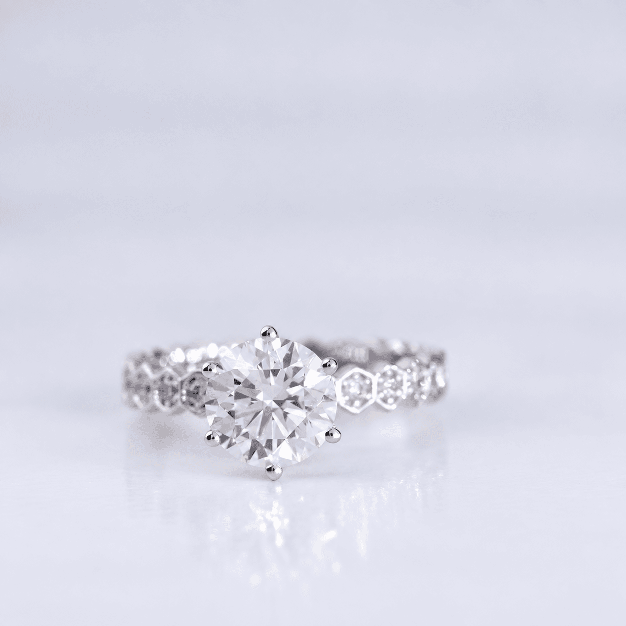 Round solitaire ring with hex-link diamond shoulders