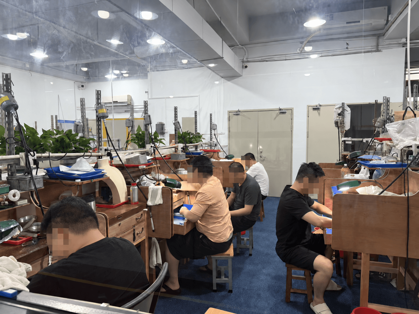 Jewelry artisans at work with faces pixelated for privacy