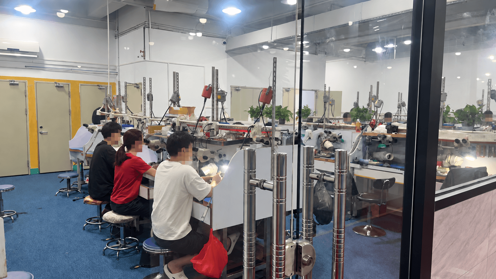 Jewelry production team with faces pixelated for privacy